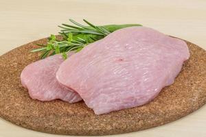 Turkey steak on wooden board and wooden background photo