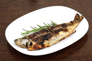 Grilled trout on the plate and wooden background photo