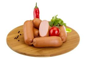 Sausages on wooden board and white background photo