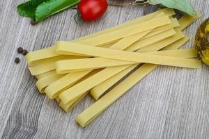 fettuccine sobre fondo de madera foto