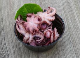 Marinated octopus in a bowl on wooden background photo