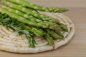 Raw asparagus on wooden board and wooden background photo