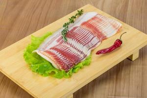 Bacon on wooden board and wooden background photo