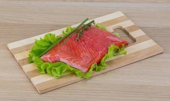 Salmon on wooden board and wooden background photo