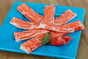 Crab sticks on the plate and wooden background photo