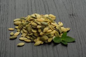 Pumpkin seeds on wooden background photo