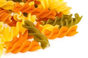 Uncooked pasta fusilli in different colours, white background photo