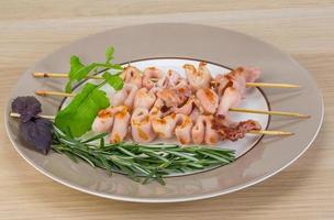 Grilled squid on the plate and wooden background photo