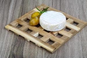 Brie cheese on wooden board and wooden background photo