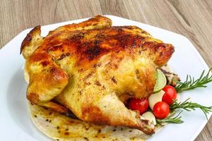 Grilled chicken on the plate and wooden background photo