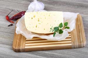 Cheese on wooden board and wooden background photo