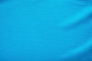 Blue football jersey clothing fabric texture sports wear background, close up top view photo