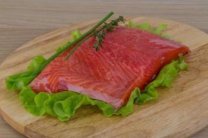 Salmon on wooden board and wooden background photo