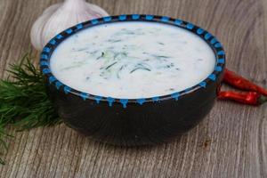 Tzatziki in a bowl on wooden background photo