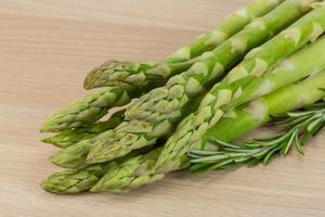 Raw asparagus on wooden board and wooden background photo