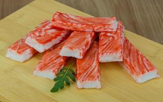 Crab sticks on wooden board and wooden background photo