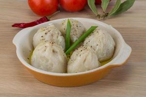 Khinkali in a bowl on wooden background photo