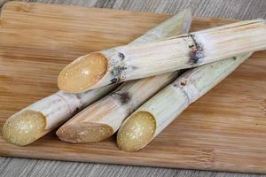 palitos de azúcar en tablero de madera y fondo de madera foto