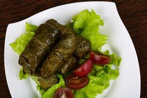 Dolma on the plate and wooden background photo