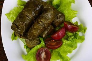 Dolma on the plate and wooden background photo