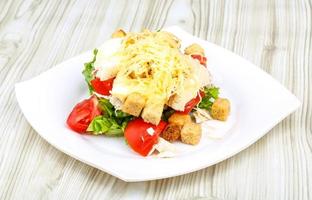 ensalada césar en el plato y fondo de madera foto