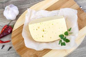 Cheese on wooden board and wooden background photo