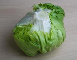 Iceberg salad on wooden board and wooden background photo