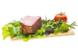 Smoked beef on wooden board and white background photo