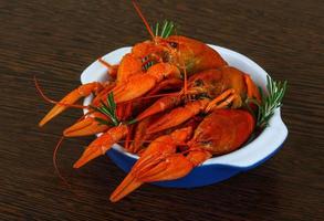 Crayfish in a bowl on wooden background photo