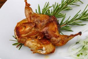 Grilled quail on the plate and wooden background photo