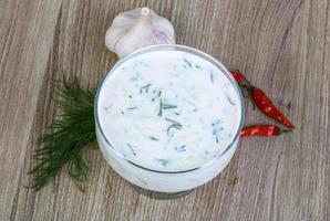 Tzatziki in a bowl on wooden background photo