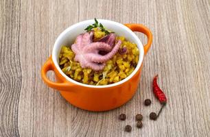 Seafood risotto in a bowl on wooden background photo