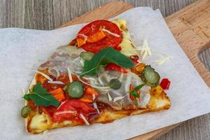 Pizza on wooden board and wooden background photo