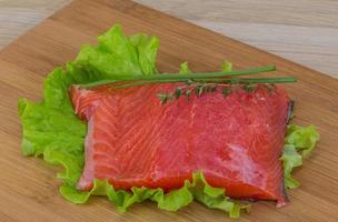 Salmon on wooden board and wooden background photo