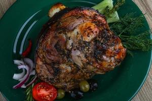 Pork knee on the plate and wooden background photo