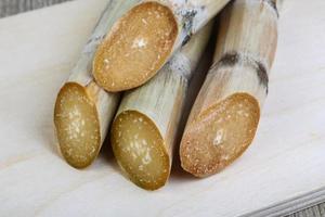 palitos de azúcar en tablero de madera y fondo de madera foto