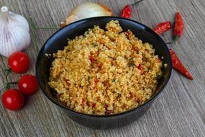 Couscous in a bowl on wooden background photo