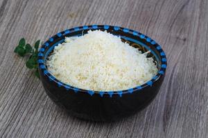 Shredded parmesan in a bowl on wooden background photo