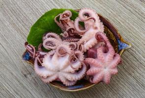 Marinated octopus in a bowl on wooden background photo