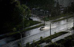 coches en el bulevar bajo la lluvia con agua salpicada. foto