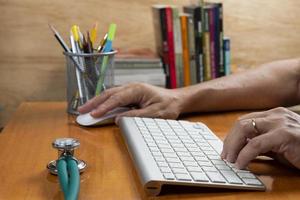 Person with hand on keyboard at an office desk photo