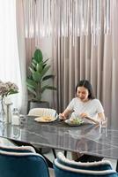 salad concept the woman sitting on dining table and having breakfast including a plate of mix salad and slices of toast