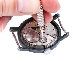 Reparador repara reloj antiguo aislado en blanco foto