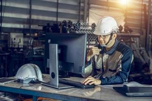 Asian project engineers who control production line facilities Use computers with AI screens, enhanced machine learning assembly processes. photo