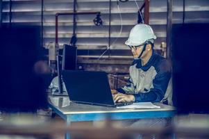 Asian project engineers who control production line facilities Use computers with AI screens, enhanced machine learning assembly processes. photo