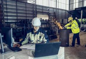 Asian project engineers who control production line facilities Use computers with AI screens, enhanced machine learning assembly processes. photo