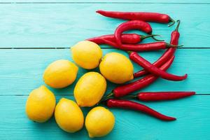 Lemon red, pepers on blue wooden kitchen background. Copy space and mock up photo