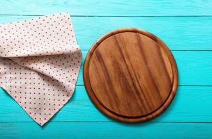 Frame of cutting board on polka dots tablecloth. Blue wooden background in the cafe. copy space photo