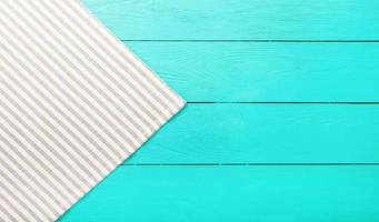 Striped gray and white material on blue wooden background. Top view and copy space. Mock up photo