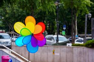 Colourful Wind turbine in the city on the road and a lot of car are driven on it. photo